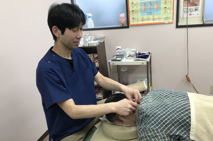首の施術をする男性