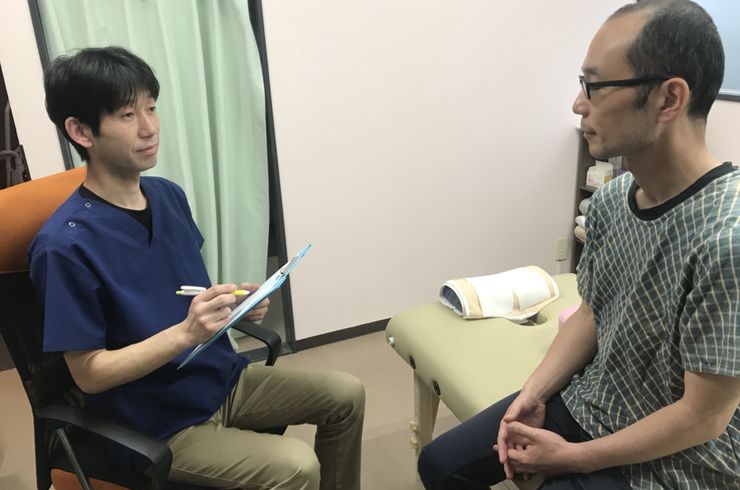 症状の聞き取りをする男性